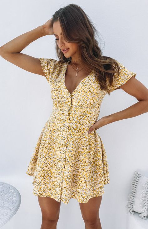 The Roxy Dress Yellow Floral is the sweetest everyday dress for Summer. Style this dress with a pair of white sneakers for a cute but casual look.     Yellow floral dress  V neckline  Button detailing down the front  Fully lined  Ties up at back Soft Summer Yellow, Summer Yellow Dress, Gabriela Montez, Yellow Floral Print Dress, Bohemian Mini Dress, Summer Dresses Online, Roxy Dress, Flowy Mini Dress, Yellow Floral Dress