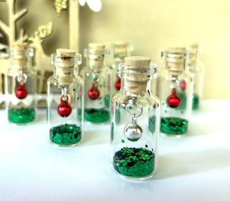 Buy any 5 bottles, get 20% off total order. Use code SAVE20 Please message us if you would like a ribbon for hanging. These tiny bottles are super fun! Holiday themed with your choice of bell and glitter! Please let us know in messages if you would like a metal loop and ribbon for hanging. The bottle measures approximately 5/8 by 1 1/2 inches.  These are repurposed bottles which we clean so keep in mind they're not perfect. Some have small spots or tiny scratches but are only visible if you look Diy Bridal Gifts, Mini Glass Bottle Crafts, Small Glass Bottle Crafts, Christmas Mini Bottle Gifts, Tiny Glass Bottle Crafts, Tiny Glass Bottles Craft Ideas, Mini Glass Bottles Ideas, Tiny Glass Bottle Ideas Christmas, Mini Glass Bottle Necklace