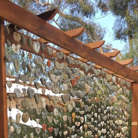 Happy Gardens 😀 on Instagram: "“My heart rock wall ❤️ with copper wire, no drilling.” . 📸: Lynette La Mere" Heart Rock Garden Ideas, Rock Hanging Decor, Outdoor Rock Collection, Heart Rock Display Ideas, Outdoor Rock Display, Heart Rock Garden, Pebble Mural, Heart Shaped Rocks Display, Heart Rocks Display Ideas