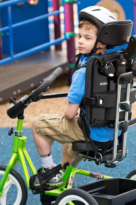 A boy wearing a helmet in a lime green Rifton Adaptive Tricycle Student Wellness, Adaptive Bikes, Gait Training, Gross Motor Activity, Pediatric Physical Therapy, Vision Therapy, Sensory Rooms, Power Training, Muscular Endurance