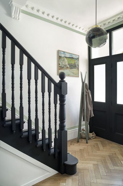 A classic combination of herringbone wooden floor, dark paintwork on the front door and stair banister set against crisp white walls for a monochrome look. Black And White Staircase, Contemporary Hallway, Victorian Hallway, White Staircase, Painted Staircases, Black Stairs, Hallway Colours, Paint Your House, Hallway Inspiration