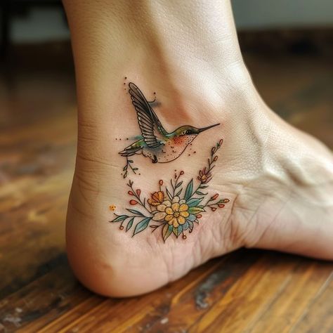 Delicate hummingbird tattoo on ankle with intricate floral design, vibrant colors, and wooden floor background. Beautiful Fish Tattoo, Spiritual Hummingbird Tattoo, Hummingbird Lotus Tattoo, Hummingbird Ankle Tattoo, Turquoise Tattoo For Women, Ankle Sleeve Tattoo, Hummingbird Tattoo Color, Hummingbird Sleeve Tattoo, Palm Size Tattoos Ideas