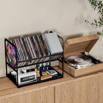 Bottom tray design to store other music-related items such as record cleaners, and more. 17 Stories | 17 Stories Metal 13.4" H Storage Rack Metal in Black | 13.4" H X 15.7" W X 9.4" D | Wayfair Cd Holder Aesthetic, Musician Bedroom, Vinyl Records Storage Ideas, Vinyl Holders, Record Player Setup, Vintage Music Room, Records Holder, Cd Stand, Vinyl Holder