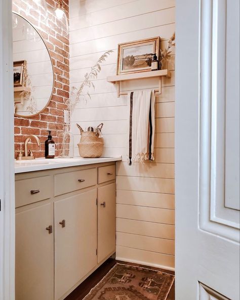 Shiplap and brick tiles were added to this farmhouse bathroom to create a more modern feel all while using elements that are found in the original architecture! Soft colors, natural wood custom built shelves and brass accents really pop against this beautiful brick wall. Brick Bathroom Ideas, Brick Bathroom Wall, Brick And Shiplap, Brick Tiles Bathroom, Powder Room Update, White Powder Room, Brick Bathroom, Brick Accent Wall, Shiplap Bathroom