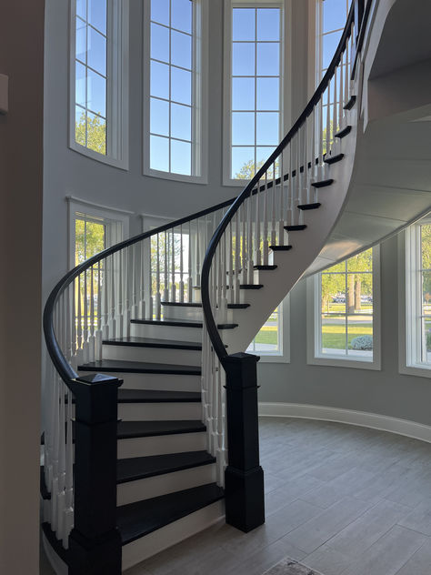 Another finished project! We love how this custom curved staircase turned out! This stairway features many standard wooden stair parts that are both painted and stained. It also has a custom winder treads made to fit the curve of this gorgeous staircase. Interested in a similar style staircase for your home? Follow the link to learn what stair parts were used! Curved Metal Staircase, Floating Curved Staircase, Round Staircase Railing Design, Curvy Staircase, Staircase Curved, Stairway Railing Ideas, Circle Stairs, Stairway Remodel, Gorgeous Staircase