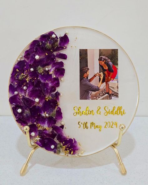 Preserved Engagement bouquet of Orchids in a desk photo frame ❤️✨️ My client Siddhi wanted to get her engagement flowers Preserved in a minimalistic keepsake, that can be placed on the work desk alongwith a keychain. So, I made this pretty keepsake with gorgeous orchids (they have my ❤️). The shimmery white background compliments the purple orchids & the pearls & gold flakes enhances the beauty of the frame. After loads of photos shared by the client, we finalized this one as it is very clo... Resin Art Photo Frame, Bouquet Of Orchids, Engagement Bouquet, Engagement Flowers, Purple Orchids, Work Desk, Gold Flakes, A Desk, Resin Art