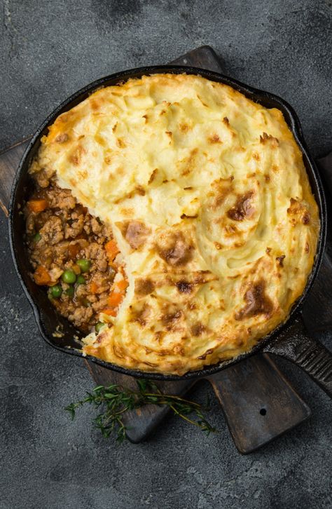 A cast iron skillet holds a shepards pie. Some of the mashed potato topping has been eaten, revealing ground beef, peas, and carrots underneath. British Food Traditional, Shepard S Pie, Vegan Shepherds Pie, Potato Puffs, Shepards Pie, Shepherds Pie Recipe, Cheesy Potato, Leftover Mashed Potatoes, Mashed Potato Recipes