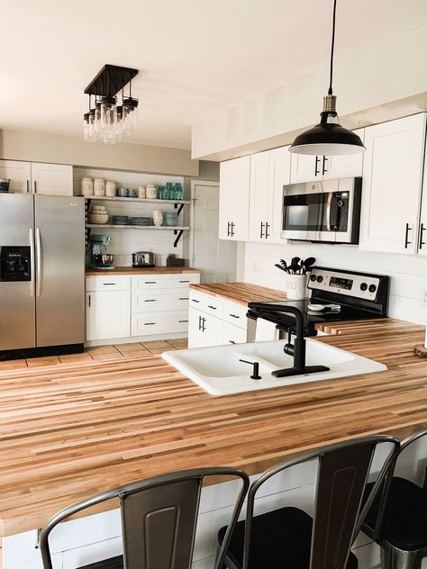 White and black kitchen makeover. Butcher block countertops, black cabinet pulls and light fixtures, shiplap and metal bar stools. We are in love! Grey Walls White Cabinets Kitchen, Butcher Block Countertops Black, Countertop Redo, Barn Office, Wood Shelves Kitchen, Kitchen Storage Bench, Countertops Black, Lighting Makeover, Block Countertops