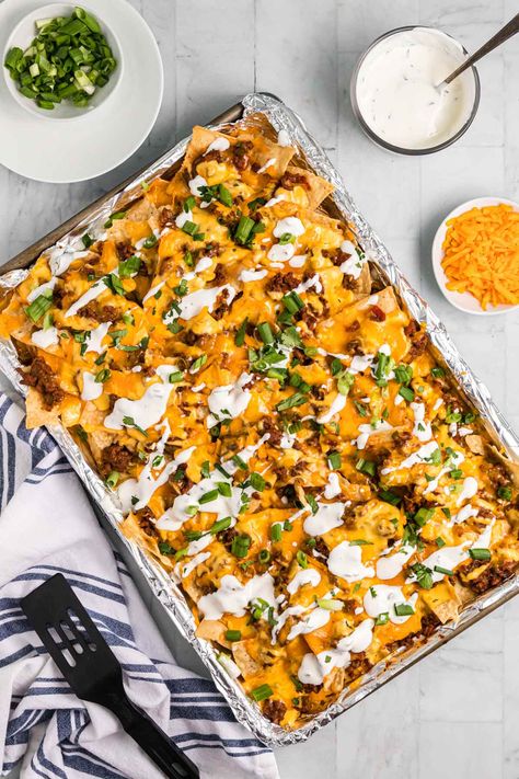 Chili Nachos topped with a creamy cheese sauce, cilantro sour cream, and green onions is a great way to use up leftover chili. Chili Nachos Recipe, Leftover Chili Recipes, Baked Chili Cheese Dogs, Gameday Snacks, Chili Cheese Nachos, Nachos Recipes, Chili Nachos, Green Onions Recipes, Game Day Recipes