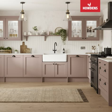 Discover Howdens Chilcomb Antique Rose Kitchen, a perfect fusion of traditional charm and modern style. These pink kitchen cabinets are both timeless and trendy. Dive into our pink kitchen ideas for inspiration and explore the versatility of shaker cabinets in a range of captivating colors. Quartz countertops add not only elegance but also durability to your kitchen design. Complete the look with a classic butler sink, and accentuate it with kitchen shelf decor against white panelled walls. Utility Toilet, Pink Kitchen Inspiration, Shaker Kitchen Ideas, Howdens Chilcomb, Pink Kitchen Cabinets, Lounge Storage, Taupe Kitchen Cabinets, Howdens Kitchen, Beige Kitchen Cabinets