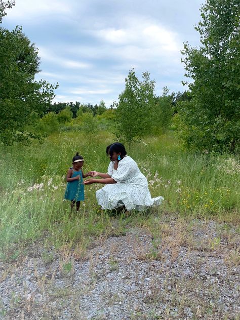 Black mother and daughter in 
blue and white floral dress in flower field Cottagecore Parenting, Black Women Homesteading, Black Farm Girl Aesthetic, Cottagecore Mom, Crunchy Mom Aesthetic, Cottagecore Mother And Daughter, Cottagecore Poc Women, Black Cottagecore, Crunchy Mom