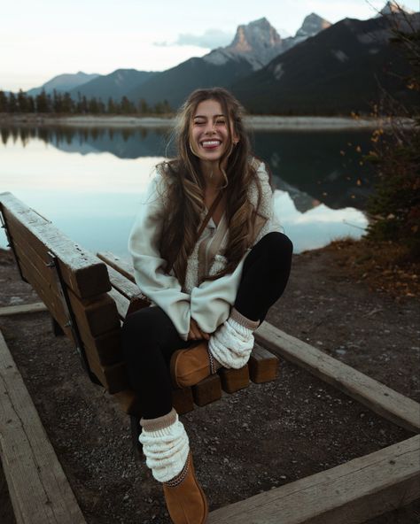 The best fall outfit ideas are the ones that are comfy, cozy, and cute! Here I’m wearing a neutral toned outfit, with a chestnut ugg tasmans, cream sherpa jacket, leg warmers, leggings, and long socks, in front of a mountain lake in Canmore!

Smile, photo inspiration, granola, girl, autumn, modest, curly long hair, layered hair, winter poses, pose ideas, bench, sitting, one leg up, tongue out, 202, 2024, eyes closed, reflection, natural makeup, casual date outfit three sisters Ugg And Leg Warmers Outfit, Mountain Date Outfit, Comfy Mountain Outfit, Lake Outfit Winter, Cute Winter Mountain Outfits, Cozy Mountain Outfits, Cute Winter Poses, Nature Tone Outfits, Leg Warmers And Uggs Outfit