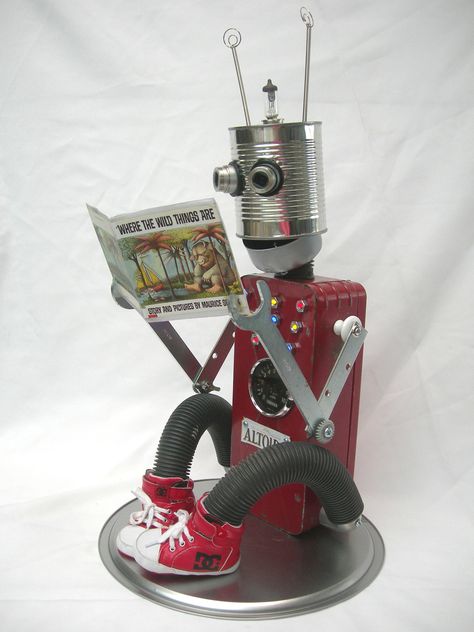 Altoids the Book Bot,  this robot was made to encourage children to read. Constructed from recycled parts.  Tin cans, tool box, wrenches, vacuum hose, pressure gauge, camera lenses, headlight bulb, springs, child basketball shoes, old skate key, lights, knobs, children's book. 24" x 12 ".  by Penny McElhaney Tin Can Robots, Steampunk Diy Crafts, Recycled Robot, Assemblage Art Dolls, Tin Can Art, Robot Sculpture, Diy Robot, Scrap Art, Trash Art