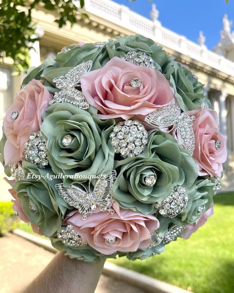 This bouquet is handmade with sage and rose gold roses with beautiful silver brooches. The design can be changed if requested. I can make it in different colors. Please message me the color. *This bouquet is 10 inches in diameter* Please contact me with any questions! :) Forest Fairy Quinceanera Theme, Sage Green Ramos, Sage Green Quince Bouquet, Sage Green And Pink Bouquet, Sage Green Quinceanera Ramo, Forest Themed Quince, Quinceñera Bouquets, Sage And Rose Gold Wedding, Quinceanera Themes Green