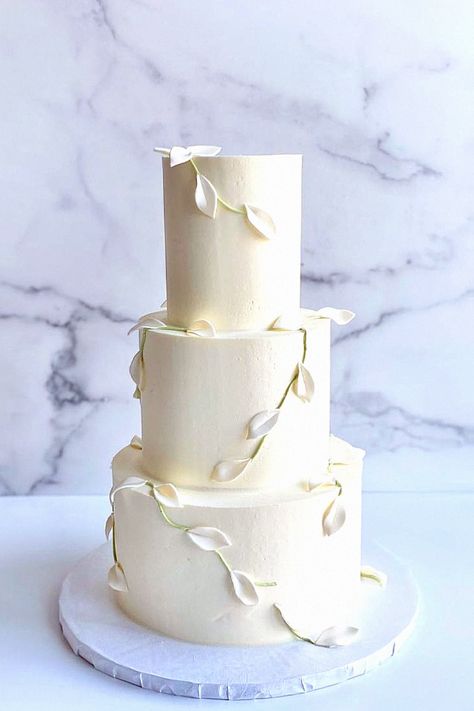 Another understated cake looks beautiful for a modern wedding. In my opinion, this style complements a simple ceremony. Pin this cake design to your wedding aesthetic ideas. Cake Wedding Minimalist, Simple Elegant White Wedding Cake, Simple Modern Wedding Cake, Minimal Wedding Cake, Wedding Cake Minimalist, Wedding Day Cake, Minimalist Wedding Cake, Wedding Aesthetic Ideas, Wedding Cake Simple Elegant