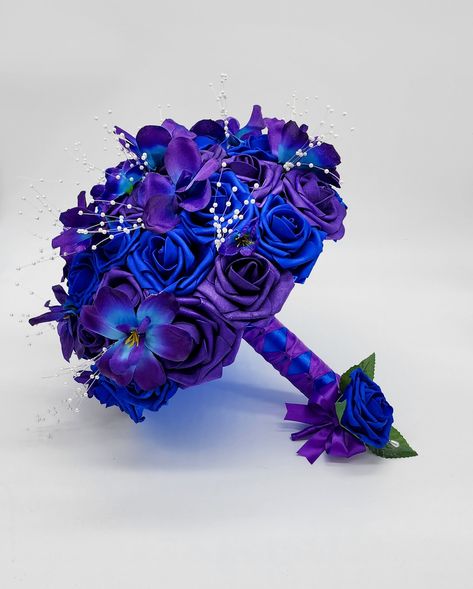 Customizable Royal Blue and Purple bridal bouquet made with real touch roses. Galaxy Orchids and pearl spray are scattered throughout bouquet. Handle is made up of royal blue and purple ribbon and finished with your choice of handle accessory.  **Our bouquets are made using high quality real touch roses, that are durable and can last a life time with the proper care. Roses feel and look real. Their petels are thick and do not fray or shed like satin flowers do. They are customizable-Change color Wedding Bouquets Purple And Blue, Royal Blue And Royal Purple Wedding, Blue Purple Black Wedding Theme, Purple And Royal Blue Wedding, Navy Blue And Purple Wedding Theme, Royal Blue And Purple Wedding Theme, Purple And Blue Wedding Theme, Royal Blue And Purple Wedding, Blue And Purple Wedding Theme