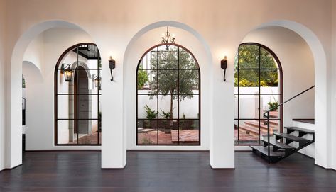 Spanish Mediterranean Elegance arched hallway and windows with white walls, iron lighting and dark wood floors | Santa Barbara Mediterranean Santa Barbara Style Homes, Spanish Mediterranean Homes, Inspirational Architecture, Santa Barbara House, Brick Pathway, Santa Barbara Style, Spanish Hacienda, Spanish Modern, Mediterranean Interior