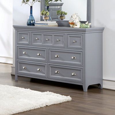 A soft gray painted finish brings an updated ambiance to this transitional seven-drawer dresser. Drawer fronts feature crown molding trim details that create wonderful texture and dimension within your stylish bedroom. They're dotted with a mix of metallic, cupped drawer pulls and round knobs for a shiny accent that allows for easy access to contents within each of the seven spacious storage drawers. | Wade Logan® Bruun 7 Drawer 56" W Dresser Wood in Brown / Gray | 36 H x 56 W x 18 D in | Wayfai Gray Dresser, Transitional Dresser, Cup Drawer Pulls, Traditional Dressers, Dresser Wood, Grey Dresser, Solid Wood Dresser, 7 Drawer Dresser, Dresser Sets