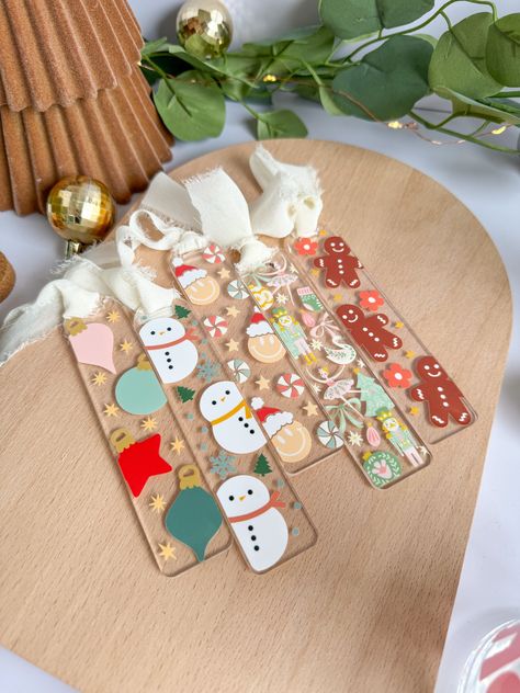 OrnamentsHoliday Christmas Acrylic Bookmark Tired of marking your page with a boring bookmarkMake reading a delight with this beautiful acrylic bookmarkDecorated with colorful ornamentsit's perfect for stocking stuffers and Christmas giftsand turns reading time into a joyous experienceIt'll brighten up your book reading experienceand make finding your page a breezeThe chiffon ribbon gives it a dynamic flair that'll make you the envy of all your book club friendsBookmarks are 5.5x1.5, and includ Acrylic Blank Bookmarks, Bookmark Acrylic Ideas, Custom Acrylic Bookmarks, Christmas Card With Ornament, Cricut Projects Bookmarks, Christmas Themed Bookmarks, Seasonal Crafts To Sell, Cute Acrylic Bookmarks, Circuit Crafts To Sell