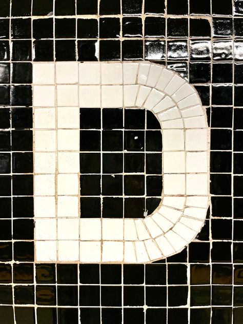 A capital D letterform made in white tile on a black background in the NYC subway system Mosaic Typography, Tile Typography, Mosaic Lettering, Mosaic Letters, New York Bar, Wall Signage, Mosaic Table Top, Interior Signs, Board Game Design