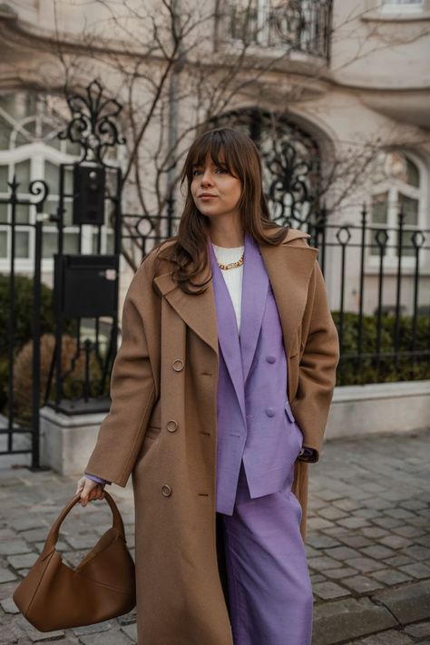 A woman wearing a camel coat with a purple suit underneath Purple Bags Outfit, Purple Coat Outfit, Brown Coat Outfit, Purple Combination, Camel Coat Outfit, Violet Brown, Purple Outfit, Burgundy Outfit, Bags Inspiration