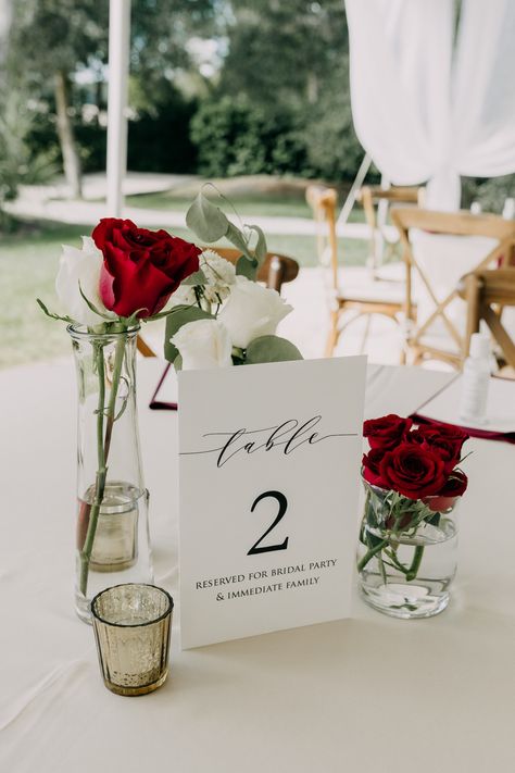 Red White Centerpieces Wedding, Romantic Dinner Centerpiece, Red Table Numbers Wedding, Elegant Red Rose Centerpieces, Minimalist Red Wedding Decor, One Rose Centerpiece, Wedding Decor With Red Roses, Burgundy And White Wedding Centerpieces, Red And White Wedding Table Decorations