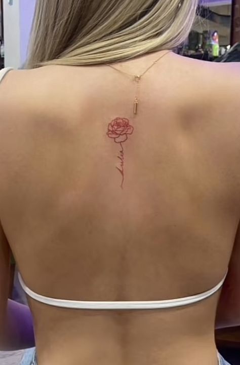 Small Center Back Tattoo Women, Flower Spine Tattoo Minimal, Red Cursive Spine Tattoo, Red Tattoos For Women Behind Ear, Small Middle Back Tattoo, Small Upper Spine Tattoo, Fine Line Spine Tattoo Women, Top Of Spine Tattoo, Back Rose Tattoo Women