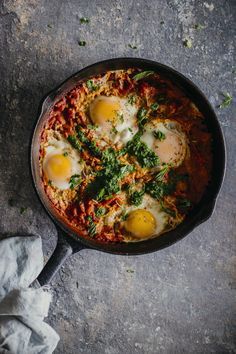 Shakshuka with Zhoug, a spicy green sauce made with aromatic herbs, originated from Yemen #breakfast #vegetarian | TheAwesomeGreen.com Breakfast Around The World, Shakshuka Recipes, Light Bites, Tomato Recipes, Healthy Vegetarian, Yemen, Egg Recipes, Brunch Recipes, Skillet