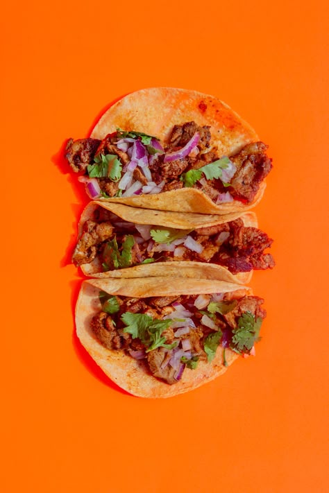 Three Al Pastor tacos on a neon orange background Food Photography Tacos, Taco Advertising, Taco Food Photography, Tacos Photography Food Styling, Mexican Food Photography, Tacos Photography, Taco Photography, Neon Orange Background, Taco Aesthetic