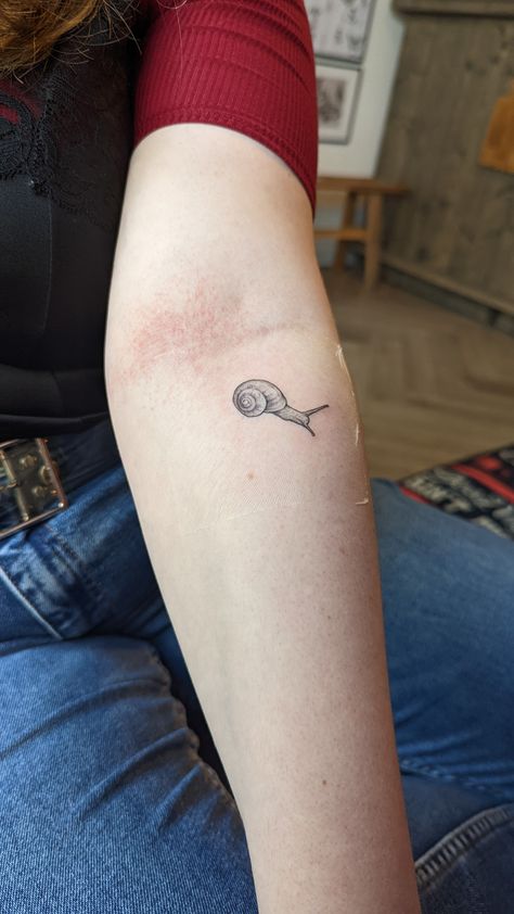 Snail tattoo in style of fineline with detail shading. Snail sits on the inside of the forearm right above the inner elbow Snails Tattoo, Snail Tattoo Ideas, Snail Tatoos, Amsterdam Tattoo Ideas, Snail With House On Back Tattoo, Cute Snail Tatoos, Cottagecore Snail Tattoo, Snail Tattoos, Fineline Tattoo Ideas