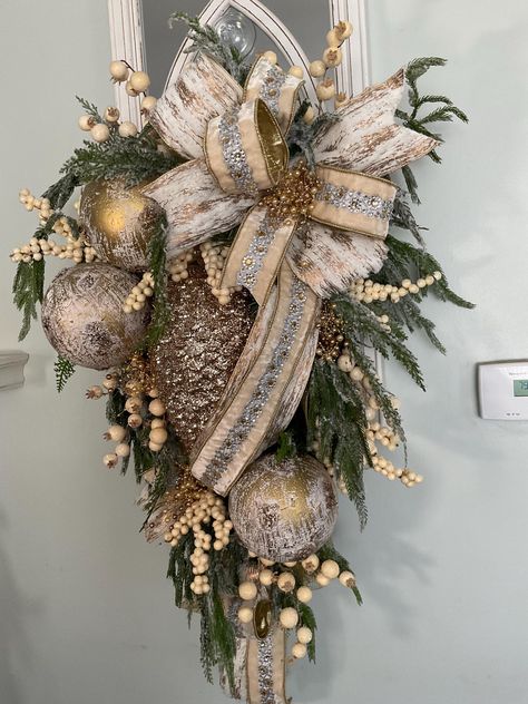 Gorgeous Winter Woodlands Swag features a giant glittered pinecone.  This swag will last all winter long with its winter greenery and giant ornaments with deluxe wired ribbon.  It's absolutely perfect for your front door or hanging on a mirror in the house.  Golds and creams and neutrals make this perfect for anyone decor. Diy Christmas Swags For Front Door, Christmas Wreaths And Swags, Swags And Wreaths, Pinecone Swag Christmas, Natural Christmas Door Swag, Rustic Door Swag, Pinecone Door Swag, Woodland Door Swag, Luxury Christmas Decor