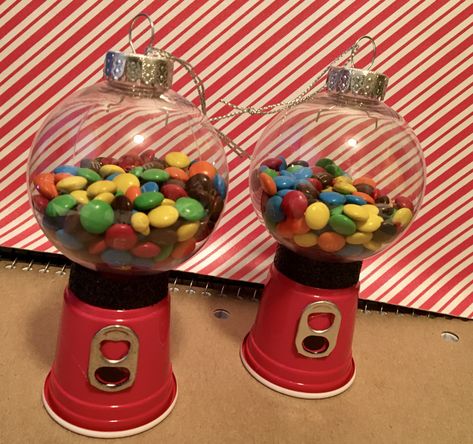 Made from dollar tree ornaments, mini solo cups, soda tabs, a little ribbon and filled with mini m and m’s. Gumball Ornament Diy, Solo Cup Christmas Ornaments, M&m Ornaments Diy, Gum All Machine Ornament Diy, Mini Solo Cup Crafts, Gumball Machine Ornament Diy, Gumball Machine Christmas Ornament, Gum All Machine Ornament, Christmas Gumball Machine Diy