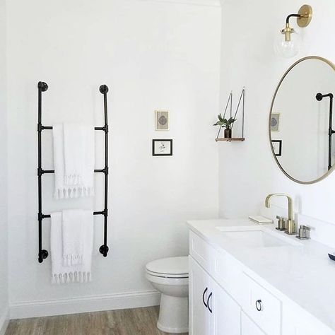 Bathroom inspiration that showcases a black metal towel rack, minimal white towels, white vanity with white countertop, mid-century mirror and shelf and minimal home decor. I can't help but love beautiful white interior design in any room! Looking for more inspo? Click here to see more home inspiration.  #homeinspiration #bathroominspiration #homedecor #whitebathroom white bathroom, minimal bathroom, black towel rack, bathroom style, wall decor Shelves Above Toilet, Decorating Bathroom, White Interior Design, Black Towels, Towel Rack Bathroom, Up House, Trendy Bathroom, Instagram Diy, Simple Bathroom