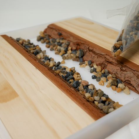 This Resin River Plank Kit comes with resin, wood planks, a silicone mold, river pebbles, and accessories to make your own beautiful river plank. This little piece of nature will bring zen to any room. Resin river plank décor has a unique blend of natural beauty and artistic craftsmanship, making it visually striking and deeply calming. The smooth flow of the resin mimics water, symbolizing tranquility, and the organic lines of the wood add a calming vibe. Whether used in home decor or as a crea Grounding Aesthetic, Epoxy Resin Crafts Ideas, Resin Crafts Ideas, Rustic Boutique, Plank Art, Resin And Wood Diy, Lipstick Plant, River Pebbles, Peaceful Energy