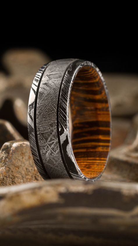 This is quite the ring! It's a 7 mm wide Kinetic Damascus band with an Acid Finish, featuring Meteorite with a Black Cerakote Accent and a Cocobolo Sleeve. Lashbrook's online builder customizes any ring to suite your personality, style and budget. Text or Call 801-352-7388 M-F 7am-6pm MST #lashbrook #menscustomring #mensweddingring Damascus Wedding Band, Damascus Steel Ring, Unique Bands, Men's Wedding Ring, Custom Ring, Damascus Steel, Damascus, Custom Rings, Wedding Band