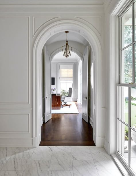 Wainscoting in Home Hallway + Arched Doorway + Marble Flooring + Dark Stained Wood Floors + Large Window + Office Space + Workspace + Wood Paneling | Jenkins Interiors Boston House, Arch Doorway, Foyer Decorating, Hallway Lighting, Home Modern, Marble Floor, Classic Interior, A Living Room, Chic Home