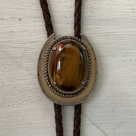 Vintage Tiger Stone bolo tie. Some believe that bolo ties inlaid with various stones offer a range of health benefits. While that may be true, we love our collection of bolo ties equally for their aesthetic qualities. This particular example features a sizeable tiger stone. On a plaited cord. Mid century modern vibes. #madeinusa (most likely) #bolotie #westernwear #cowboyclobber #mrsmartmelbourne_bolotie Tie Women Outfit, Bolo Tie Women, Tie Aesthetic, Vintage Tiger, Bolo Ties, Bolo Tie, Modern Vibe, Plaits, Men Looks