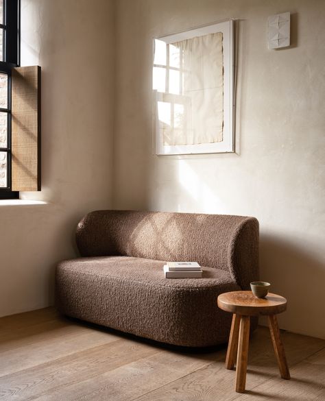 A brown loveseat upholstered with bouclé fabric by Collett & Victor and a small wooden side table Brown Boucle Sofa, Curved Loveseat, Peaceful Moments, Bed Bench, Curved Back, Organic Shapes, Love Seat, Dining Bench, Lounge Chair