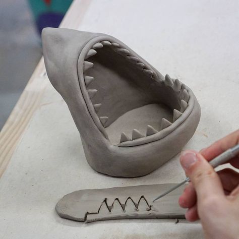 A peak at how I make shark heads. I cut out the teeth in a row but then I have to go back and sharpen each one . . .  #sharkplate #progressshot #behindthescenes #shark #teeth #clay #sculpture #sculpting #sharks #pottery #art #workinprogress #wip#ceramics #madeinaskutt # #bostonmakers#madeinboston #bostonhandmade #craftsposure#handmadeisbetter #handmadelife#makersmovement #handmadewithlove #handmadecurator#supporthandmade #etsy Clay Date, Sushi Platte, Shark Head, Cerámica Ideas, The Teeth, Tanah Liat, Slab Pottery, Pottery Crafts, Ceramics Pottery Art