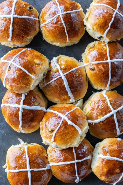 These ultra-soft hot cross buns are made with a spiced dough, juicy raisins, and a simple sweet glaze. You'll love this traditional and mouthwatering recipe! Spiced Buns, Soft Hot Cross Buns Recipe, Hot Cross Buns Recipe No Raisins, Janes Patisserie Hot Cross Buns, Hot Cross Bun Flavours, Powdered Sugar Glaze, Bread Toppings, Hot Cross Buns Recipe, Sugar Glaze