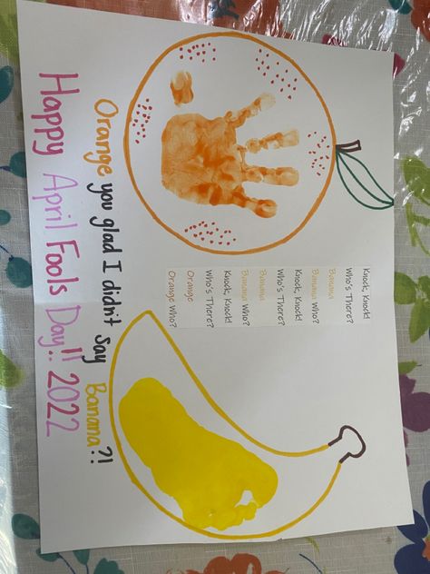 Yellow outline of a banana with a child’s yellow footprint in the middle. Orange outline of an orange with a child’s orange handprint one the middle. A typed knock knock joke glued in-between the orange & the banana. Underneath the orange & the banana handwritten punchline “orange you glad I didn’t say banana?!” with the orange written in orange sharpie & the banana written in yellow sharpie. Underneath the written punchline, handwritten in purple & pink sharpie is “Happy April Fools Day!! 2022” April Fools Toddler Craft, April Fools Art Projects For Kids, Easter Artwork For Infants, April Lesson Plans For Infants, April Fools Crafts For Infants, April Fools Arts And Crafts, April Fools Crafts For Toddlers, April Art Projects For Infants, Spring Infant Crafts Footprint Art