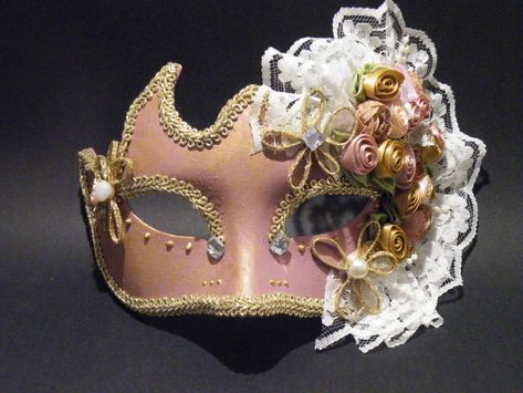 Handmade Venetian Masquerade mask covered in Old Rose Paint. Eyes are outlined with gold braid, gold paint beading and crystal rhinestones. The left side of the mask is the most elaborate part of the mask and is covered with fabric flowers in the same tones of the mask, pearls, lace and pearl beads.  It is outlined with gold trim for an exquisite finish. Can come with a ribbon covered stick to hold from or tie back ribbons. This type of mask would look lovely on any Bride for a Venetian Masquera Rose And Gold Wedding, Masquerade Mask Lace, Venetian Masks Art, Masquarade Mask, Wedding Masquerade, Harlequin Mask, Mardi Gras Masquerade, Masquerade Wedding, Venetian Masquerade Masks