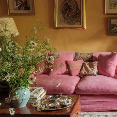 Clever with colour: Tis the season for comfy sofas, and look at this peach! This room is the perfect colour clash, and a reminder that bright can also mean harmonious. And its offset by a symphony of textures, from the wonky cottage walls to the loose linen sofa cover, the wool rug and the shiny gold frames. Perhaps unsurprisingly, the cottage belongs to an artist @occymackenzie who painted the whole house herself. Photo by @davewattsphotography #CleverWithColour #lateafternoonlife #int... Cottage Walls, Peach Living Rooms, Linen Sofa Cover, Living In London, Cosy Room, Pink Sofa, Yellow Home Decor, Cosy Living Room, Yellow Interior