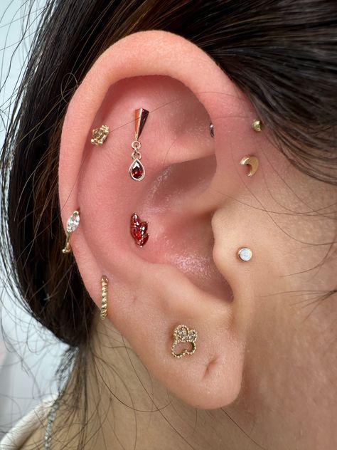 New additions to this ear curation are the best! 🥰  Conch and flat piercing by @piercing_munchkin94  Lulu Marquise 14k gold + Dark Garnet Pear CZ 14k gold from @junipurrjewelry  ⚔️livebytheswordtattoo.com⚔️ . . . . #livebytheswordtattoo #14kgold #darkgarnet #earcuration #conchpiercing #flatpiercing #piercer #nyc Ear Percinings Ideas, Ear Piercings Orbital Conch, Stretched Conch Piercing, Star Conch Piercing, Conch Ear Piercings Marquise, Piercings Ear Conch, Opal Conch Piercing, Flat Piercing, Dark Garnet