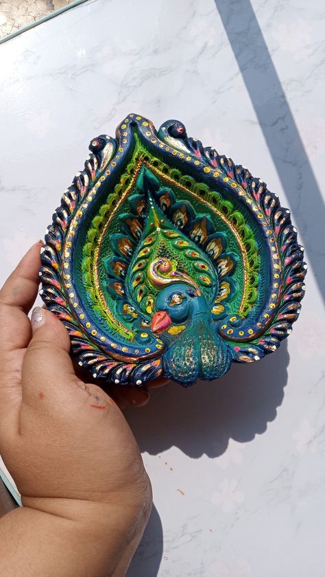 Peacock Diya Decoration, Diya Paintings Acrylic, Diwali Diya Painting Ideas, Painting On Diya, Diya Colour, Diya Paintings Acrylic Ideas, Diya Colouring Ideas, Diya Paintings For Diwali, Diya Colouring