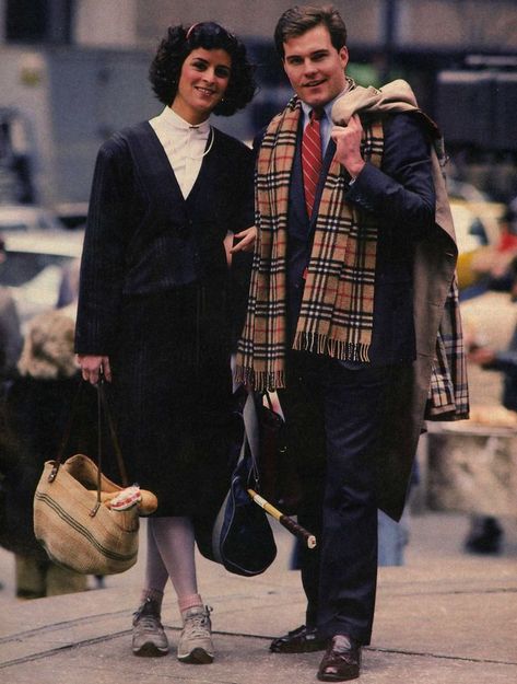 This is a photo of a couple in the "Yuppie" style of the 80s. Yuppie stood for 'Young Upwardly Mobile Professional Person'. They wore preppy upscale clothing that reflected their expensive tastes. Women often wore sneakers while commuting to work in cities. Yuppie Fashion, Fashion History Timeline, 1980s Fashion Trends, Look 80s, Fashion 1980s, 20th Century Fashion, Dapper Style, Estilo Preppy, Power Suit