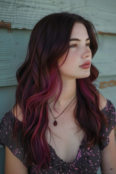 A young woman with shoulder-length ombre hair blending from dark brown to vibrant purple, looking thoughtfully to the side against a faded wooden backdrop. Haircolor Ideas For Brown Skin Tone, Dark Red On Brown Hair, Red Hair Color Ideas With Highlights, Vibrant Hair Color Ideas Brunettes, Colour Highlights Brown Hair, Red Streak In Hair, Dark Red Pink Hair, Brown Hair Red Streaks, Red Hair For Brown Skin