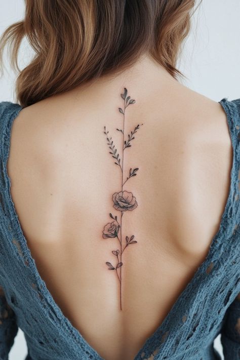 Tattoo of delicate flowers and branches along the spine on a person's back wearing a blue lace top. Fine Line Floral Back Tattoo Women, Spine Tattoo Quotes With Flowers, Script With Flower Tattoo, Poppy Flower Spine Tattoo, Spine Fine Line Tattoo, Spine Tattoo With Flowers, Floral Side Tattoos Women, Delicate Spine Tattoos For Women, Female Spine Tattoos