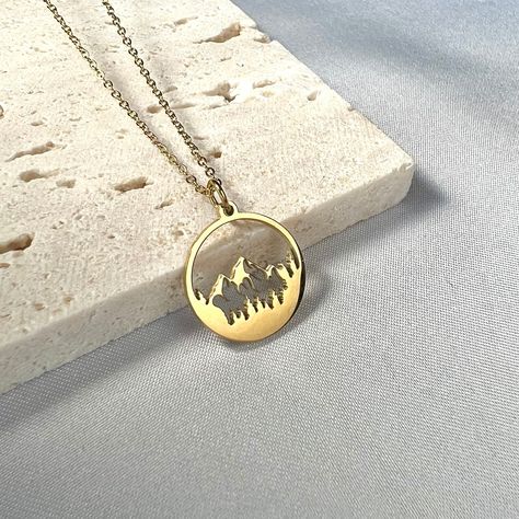 "This 18K Gold Mountain Necklace is perfect for those who love natures and scenic mountain views. The mountain charm/pendant/coin disc is dainty, minimalistic and crafted with care. This will make a great gift!  💌Specifications - Material: Stainless Steel & 18K Gold Plated  - Charm Size: 1.6cm - Necklace Length: 16.5\"+2\" / 42+5cm  (adjustable)  - Perfect for daily wear or special occasion - Durable, anti tarnish and high quality 🔨Processing Time: Please allow 1-3 days before the item ships out.  📦Shipping Time: Please select the USPS shipping option that suits you best at checkout.  🎁Gift Wrapping:  Available for extra $3, we will wrap the order pretty and ready for you in a gift box and can also hand write your personalized notes. Please fill out \"note to seller\" section with your Scene Necklace, Gold Necklace Dainty, Gold Mountain, Mountain Necklace, 18k Gold Necklace, Mountain Scene, Charm Pendant Necklace, Coin Pendant, Nature Jewelry