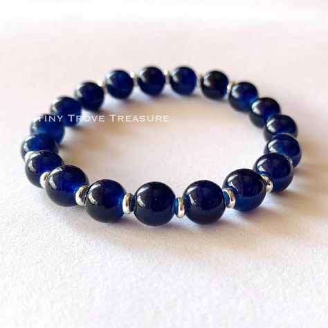 The Midnight Blueberry Bracelet… Blue Stretch Glass Bracelet- Classic Glass Round Bracelet 8mm - Unisex, Blue, Glass Bracelet Experience timeless elegance with our meticulously crafted Classic Blue Glass Bracelet, boasting captivating shades reminiscent of tranquil ocean waves. Elevate your style effortlessly with this exquisite accessory. - Classic Blue Glass Beaded Bracelet - Crafted with 8mm glass beads - Elastic design for comfort and style - Expresses unique personality effortlessly ... Blue Glass Bracelets With Spacer Beads, Blueberry Bracelet, Blue Bohemian Glass Bracelets, Handmade Blue Glass Bracelets, Elegant Blue Glass Bracelet, Blue Polished Glass Bead Jewelry, Round Bracelet, Glass Beaded Bracelet, Bracelet Blue